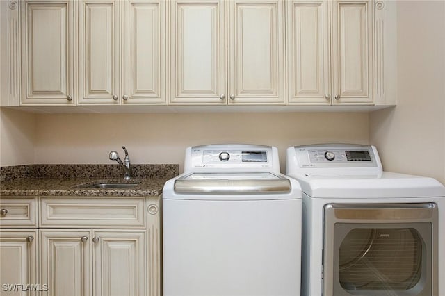 laundry room featuring cabinets, washing machine and clothes dryer, and sink