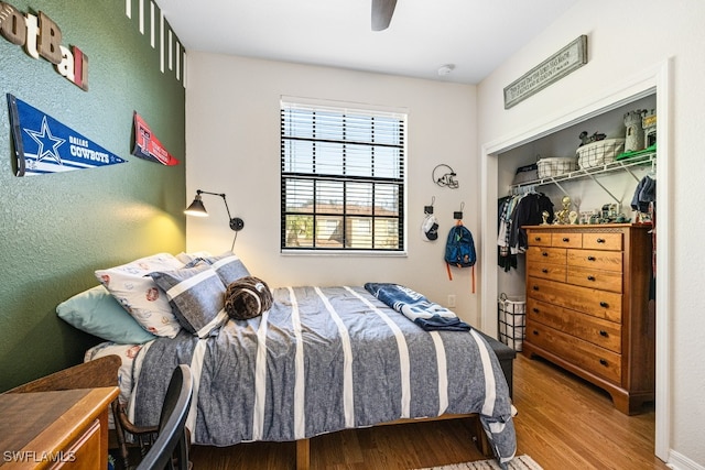 bedroom with ceiling fan, a closet, and hardwood / wood-style flooring