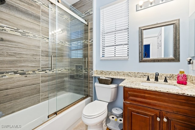 full bathroom featuring toilet, vanity, and combined bath / shower with glass door