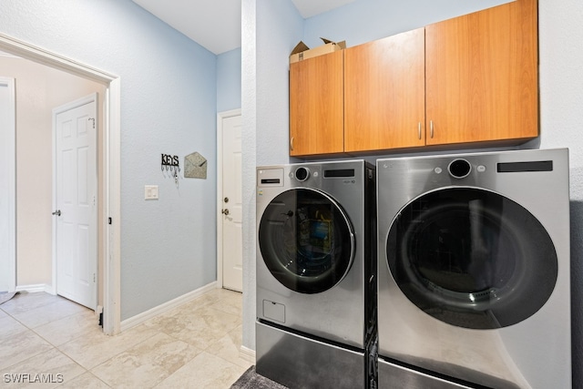 laundry room with separate washer and dryer, light tile patterned floors, and cabinets