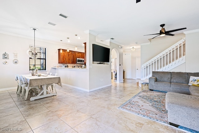 living room with ceiling fan and ornamental molding