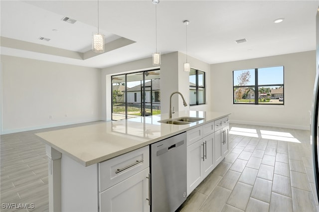 kitchen with a healthy amount of sunlight, sink, stainless steel dishwasher, and a center island with sink