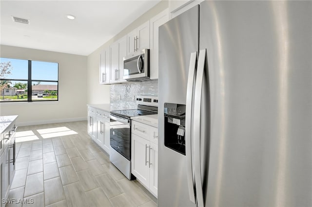 kitchen featuring white cabinets, decorative backsplash, and appliances with stainless steel finishes