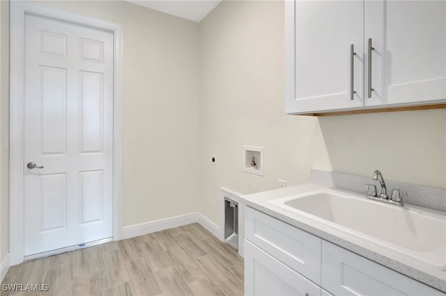 clothes washing area with sink, cabinets, hookup for an electric dryer, hookup for a washing machine, and light hardwood / wood-style floors