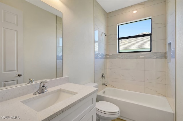 full bathroom featuring vanity, tiled shower / bath combo, and toilet