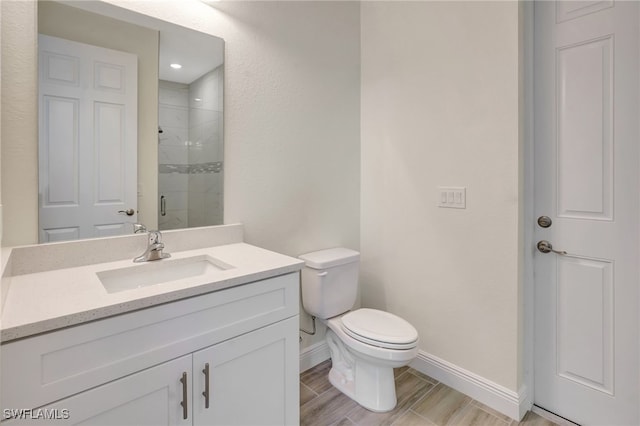 bathroom featuring hardwood / wood-style floors, vanity, toilet, and a shower with door