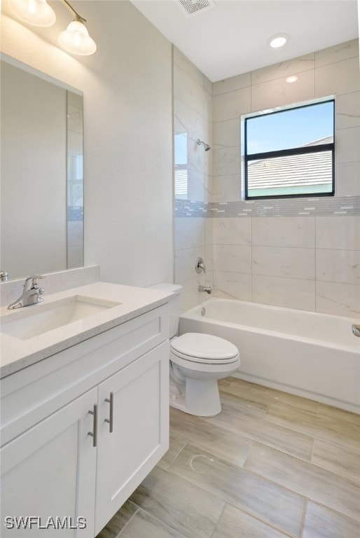 full bathroom featuring vanity, toilet, and tiled shower / bath