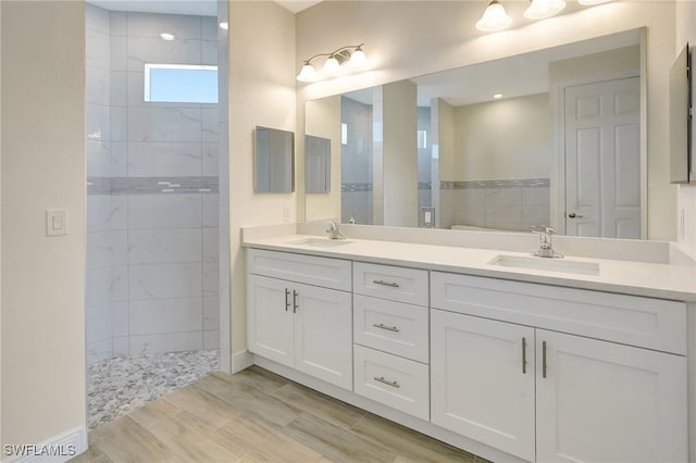 bathroom with vanity and a tile shower