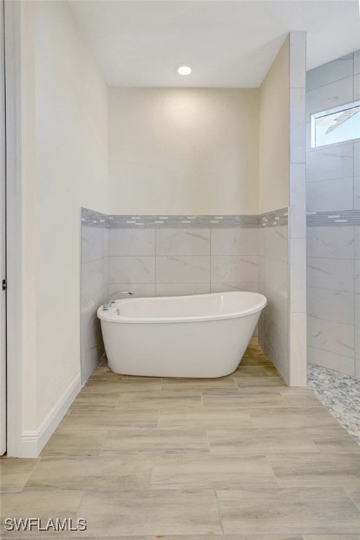 bathroom with separate shower and tub and tile walls