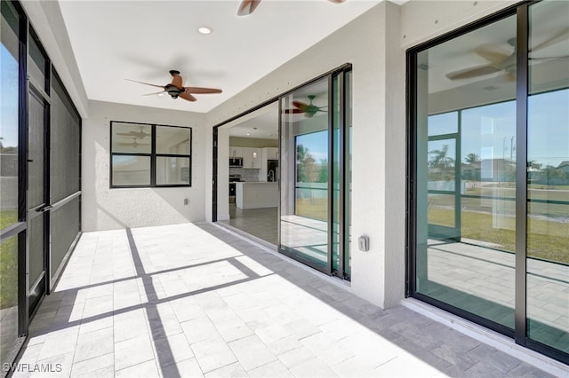 unfurnished sunroom featuring ceiling fan