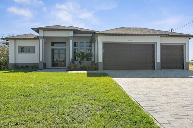 prairie-style house with a front yard, french doors, and a garage