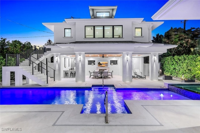 back of property with a bar, a patio, and a swimming pool with hot tub