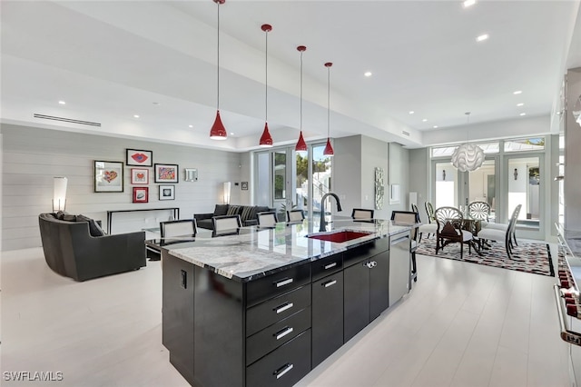 kitchen with pendant lighting, dishwasher, an inviting chandelier, a spacious island, and sink