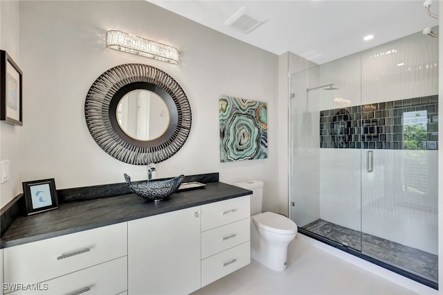 bathroom with vanity, toilet, and a shower with door