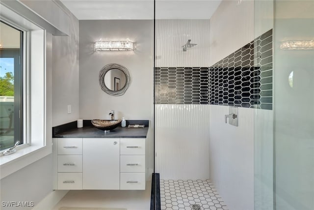 bathroom featuring tile patterned flooring, vanity, and walk in shower