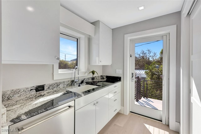 kitchen featuring white cabinetry, plenty of natural light, and sink