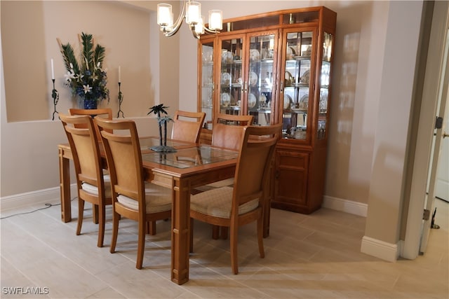 dining space with light tile patterned floors and a chandelier