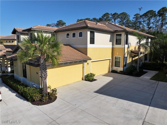 view of front of house featuring a tile roof, driveway, and stucco siding