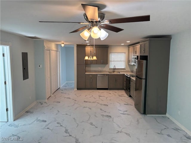 kitchen featuring ceiling fan with notable chandelier, appliances with stainless steel finishes, electric panel, and sink