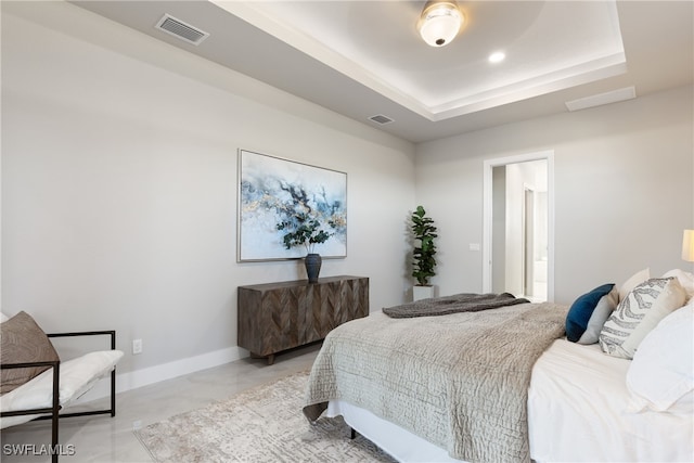 bedroom featuring a tray ceiling, ceiling fan, and ensuite bathroom