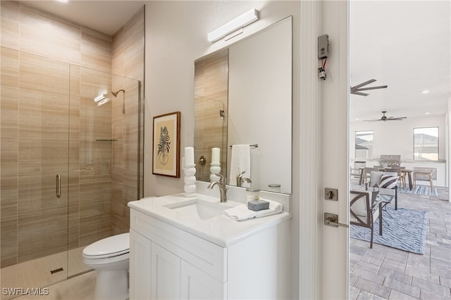 bathroom with a shower with door, vanity, and toilet