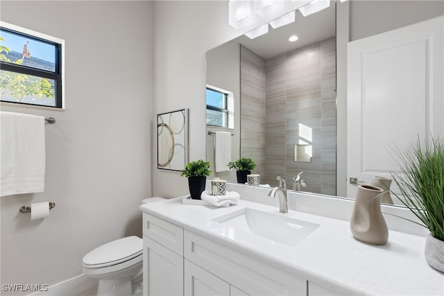 bathroom featuring vanity, toilet, and plenty of natural light