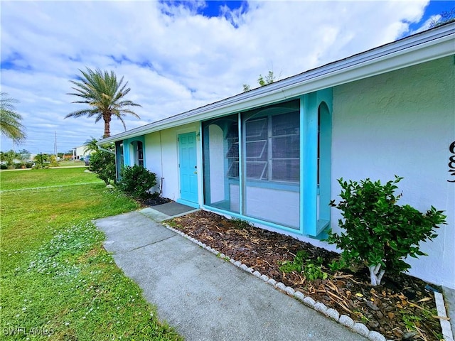 entrance to property with a lawn