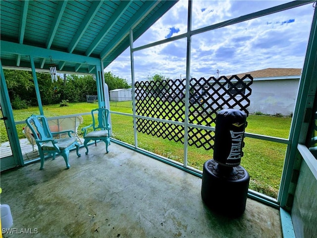 unfurnished sunroom with vaulted ceiling with beams