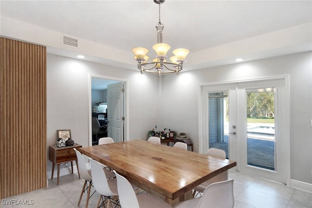 tiled dining area with french doors and a notable chandelier