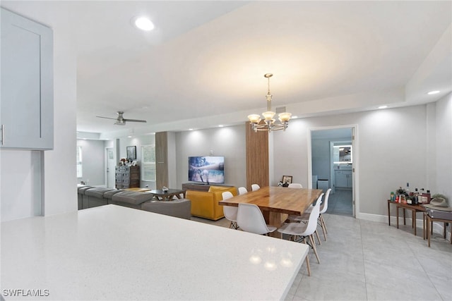 dining room with light tile patterned floors and ceiling fan with notable chandelier