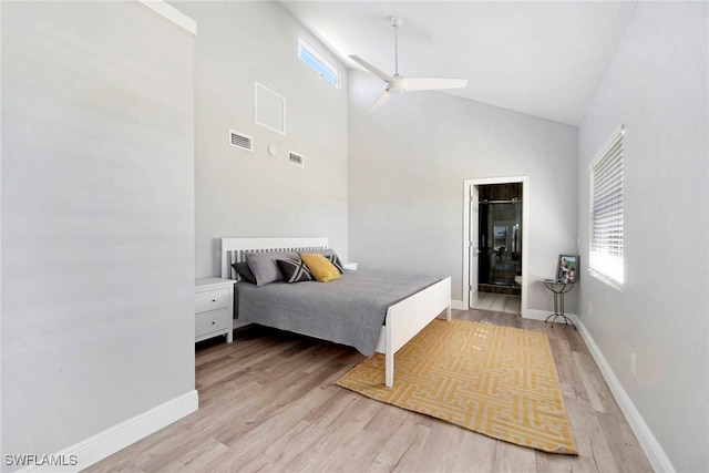 bedroom with ensuite bath, light hardwood / wood-style floors, high vaulted ceiling, and ceiling fan