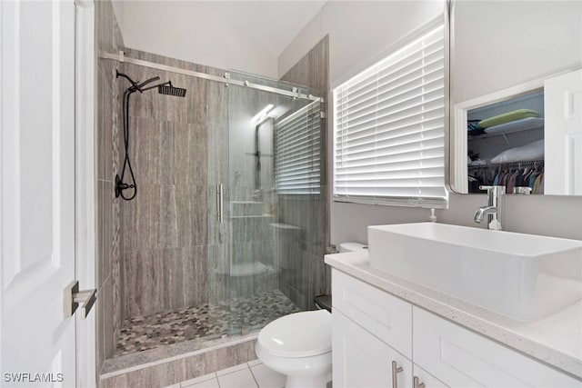 bathroom featuring tile patterned floors, vanity, toilet, and an enclosed shower