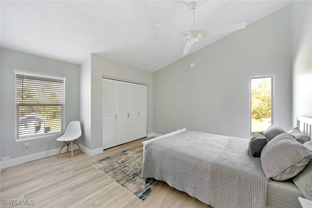 bedroom featuring a closet, multiple windows, ceiling fan, and light hardwood / wood-style flooring