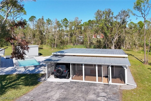 rear view of house with a sunroom and a yard