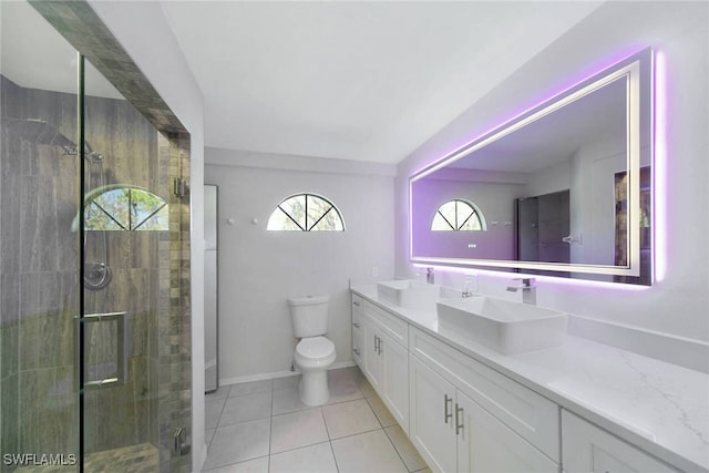 bathroom featuring tile patterned floors, toilet, vanity, and walk in shower