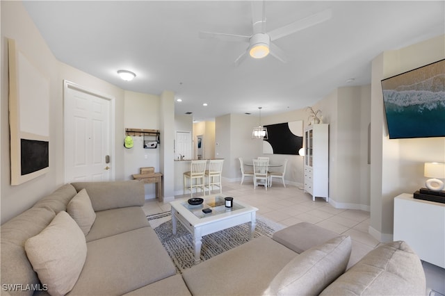 living room with ceiling fan with notable chandelier and light tile patterned flooring