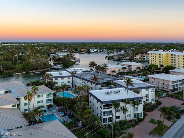 aerial view at dusk featuring a water view