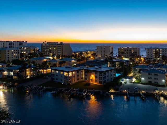 aerial view at dusk featuring a water view