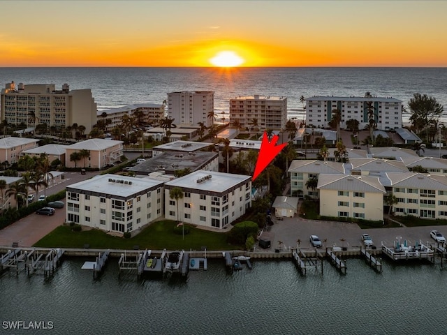 aerial view at dusk featuring a water view