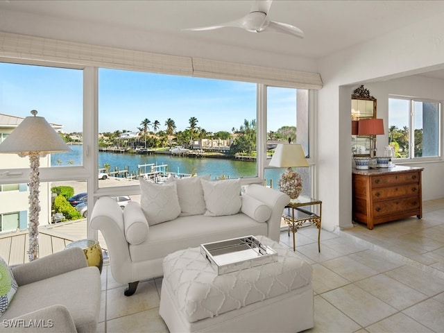 sunroom featuring a water view and ceiling fan