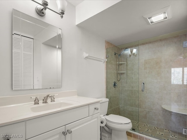 bathroom with tile patterned flooring, a shower with door, vanity, and toilet