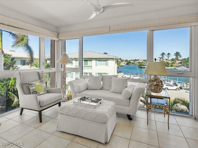 sunroom / solarium featuring ceiling fan and a water view