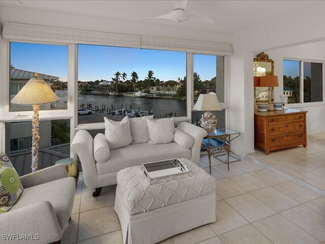 sunroom with a water view and ceiling fan