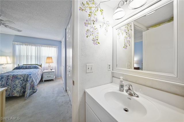 bathroom featuring vanity, ceiling fan, and a textured ceiling