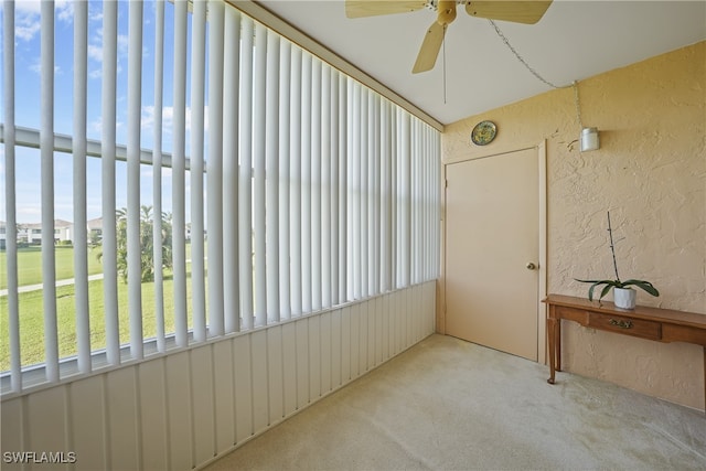 unfurnished sunroom with ceiling fan