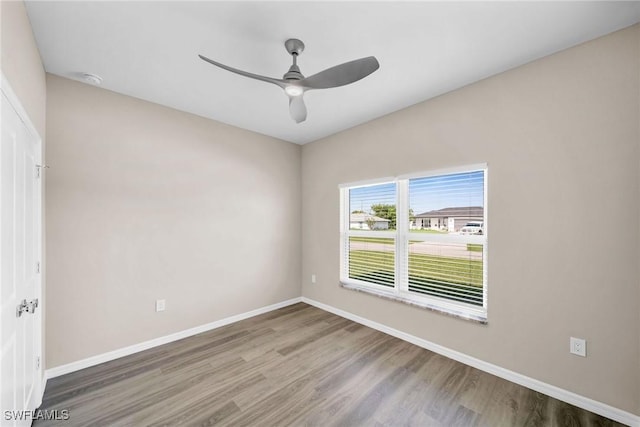 unfurnished room featuring ceiling fan, baseboards, and wood finished floors