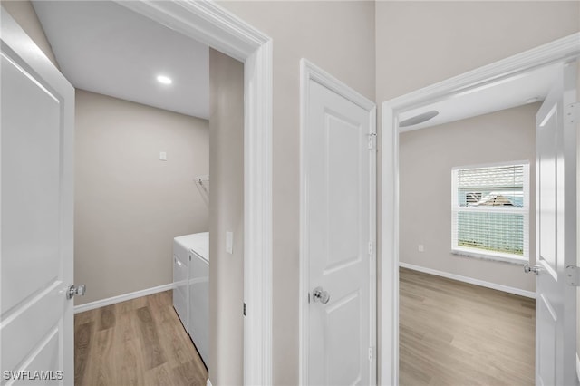 laundry room featuring light wood-type flooring and washer and clothes dryer