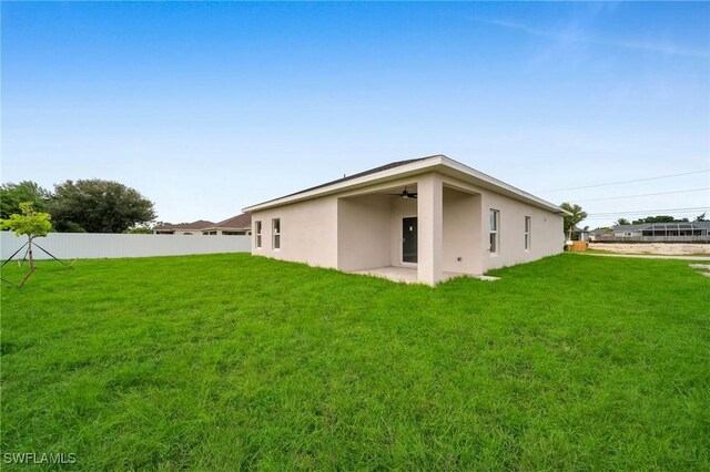 rear view of property featuring a yard and a patio