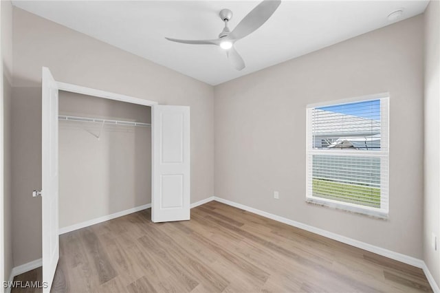 unfurnished bedroom featuring light wood-type flooring, a closet, and baseboards