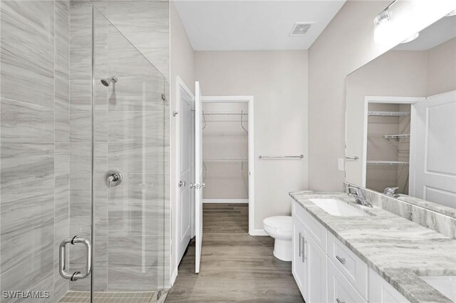 bathroom with vanity, hardwood / wood-style flooring, toilet, and an enclosed shower